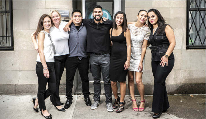 Soul Dental hygienists and assistants pose together in a row, arms around one another. They are dressed up and appear to be celebrating.